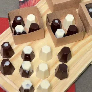 Bombons Lo Pane em chocolate branco e meio amargo, sobre tábua de madeira e em caixas de presente