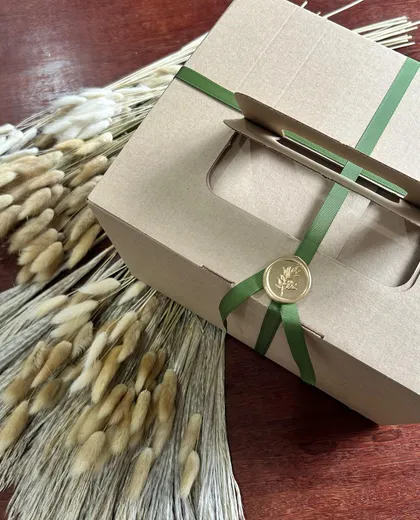 Caixa da Lo Pane fechada com fita verde e selo de cera dourado, pronta para entrega