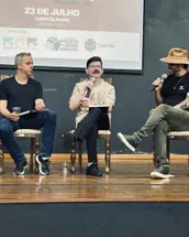 Fábio da Lo Pane falando ao microfone no Painel 02 do 12º Encontro da Frente da Gastronomia Mineira, com o banner do evento ao fundo